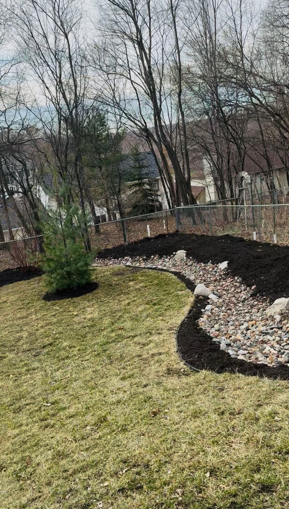 Project Fresh Mulch, River Rocks, and Young Trees Planted in One Backyard image